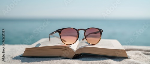 Open book rests on sand near ocean