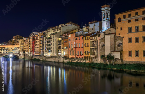 Cityscape with medieval gothic buildings by the famous bridge of Ponte Vecchio on Arno River in Centro Storico, Florence, Italy after sunset at night