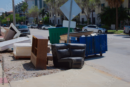 Canvas Print Discarded mattresses and sofa cushions stacked at the curb outside a modern apartment complex, showing bulk trash removal, urban cleanup challenges and neighborhood waste on a sunny day