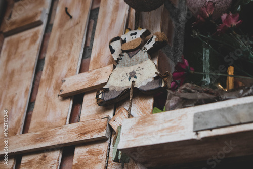 Vintage handmade wooden cow decoration on a rustic timber wall