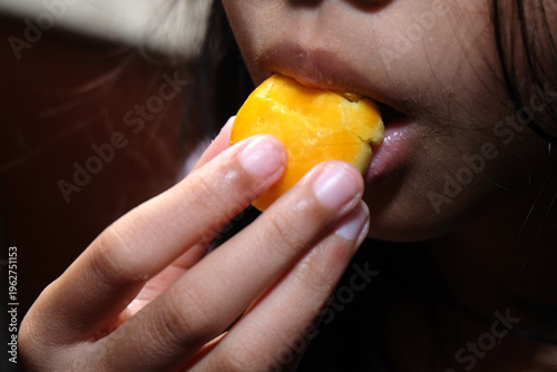 Fotografia candid shot showing a person taking a bite of the same golden pastry