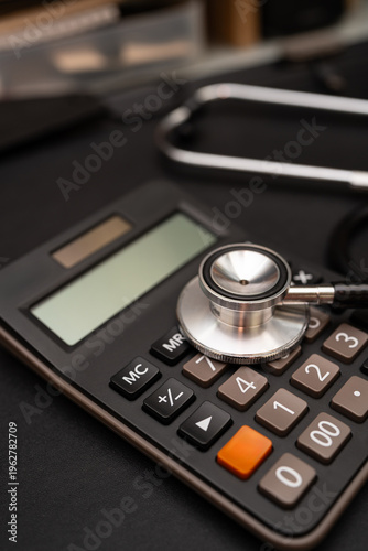 Stethoscope and Calculator on Black Background Representing Healthcare Costs and Financial Planning. Medical expenses, health insurance, financial budgeting for healthcare, and medical industry.