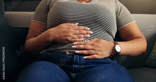 Fotografía Hands, stomach ache and woman in home with pain, endometriosis or menstrual cramps on sofa