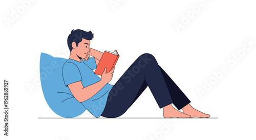 Young man relaxing comfortably while leaning against a large blue pillow and reading an interesting book at home.