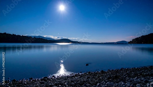 Serene Moonlit Lake Reflecting Bright Moonlight Over Calm Waters.