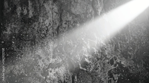 A beam of light shines on a dark and textured surface with visible speckles and cracks