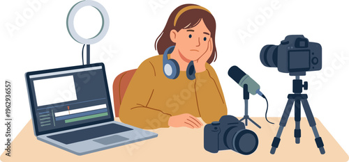 A woman sits at a desk recording a video with a laptop camera microphone and headphones on