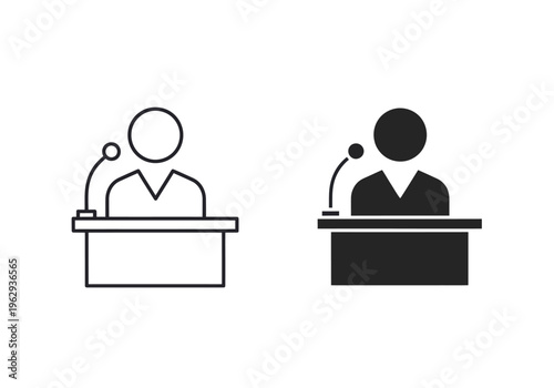 Two people are standing at podiums with microphones in a formal debate setting indoors.