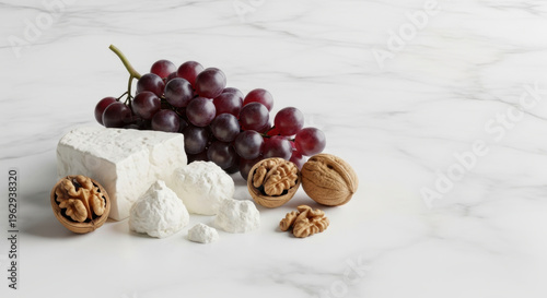 Creamy soft cheese, purple grape cluster and crunchy walnut halves arranged on white marble surface, elegant snack still life with cozy mood