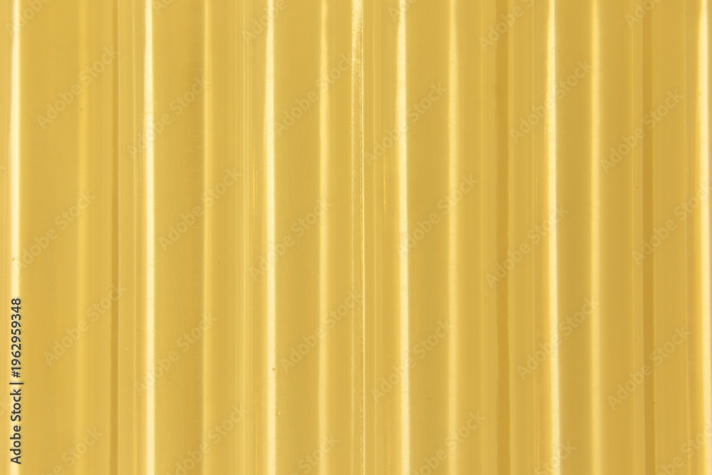 Obraz premium Abstract ribbed smooth yellow golden striped plastic pattern or texture as background