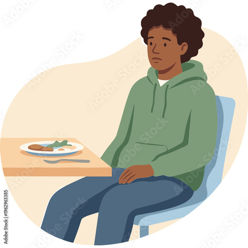 A young boy sits alone at a table eating a meal with a plate of food
