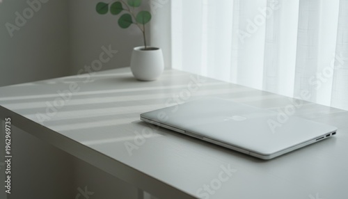 Closed Silver Laptop Resting on Minimalist White Office Desk