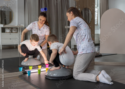 Pediatric Occupational Therapist Helping Young Boy Practice Balance Exercises With Playful Toys