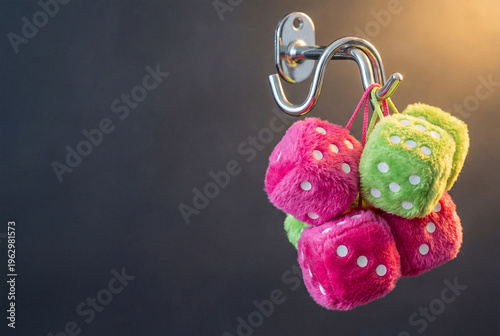 Fluffy pink and green dice hanging on a chrome hook