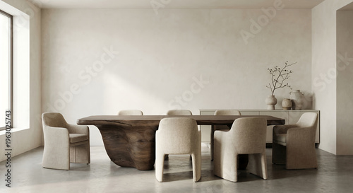 A minimalist dining room features a large, live-edge wooden dining table surrounded by upholstered chairs, with a sideboard displaying decorative vases and a branch in the background.