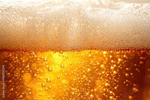 Refreshing close up of golden alcoholic beer with light shining through liquid. fine bubble of drink and beverage rises to rich foam for satisfying moment