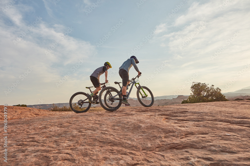 Fototapeta premium People, training and cycling in nature with mountain bike, adventure or workout together for fitness. Space, friends and countryside journey with bicycle, rock terrain or cardio exercise for wellness