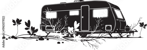 Black and white of camper trailer surrounded by plants