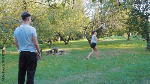 Mother and Teenage Son Playing Frisbee in Sunny Green Garden: Active Family Lifestyle Outdoors