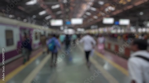 Bokeh view of passengers at the CSMT (Chhatrapati Shivaji Maharaj Terminus) railway station, Mumbai, India. Blurred background footage.