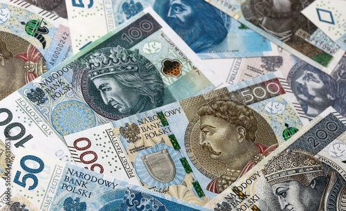 Polish zloty money bills pile on table. Poland banknotes of PLN currency close up.