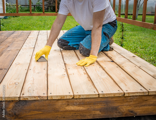 Wallpaper Mural Worker smooths new wooden deck planks with care Torontodigital.ca