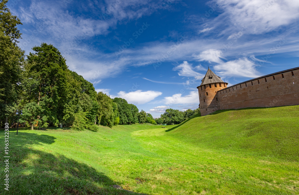 Fototapeta premium Ancient tower stands tall on green hillside