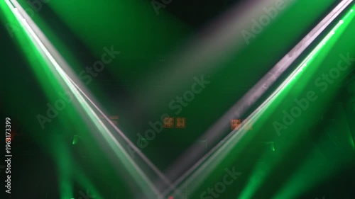 Bright green spotlights cut through the dark atmosphere of an empty stage or venue. The dynamic beams create circular patterns on the floor, evoking an energetic mood for a concert or live event.
