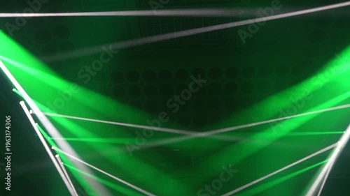 Bright green spotlights cut through the dark atmosphere of an empty stage or venue. The dynamic beams create circular patterns on the floor, evoking an energetic mood for a concert or live event.
