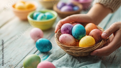 Woman holding basket with colorful painted eggs on wooden table. Traditional decoration for Easter holiday celebration. Concept of creative spring activity and festive food preparation.