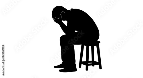 Silhouette of a man sitting on a stool with his head in his hands, conveying despair.