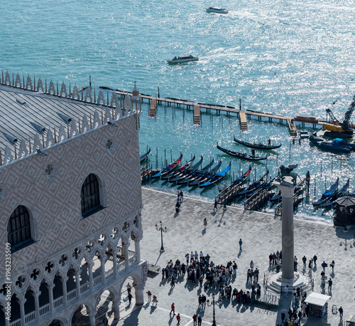 Sunlit Venetian waterfront with gondolas and tourists