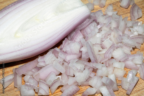 Close up of a chopped shallot onion on a wooden chopping board