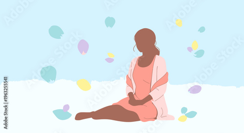 Woman sitting on the ground surrounded by colorful petals.