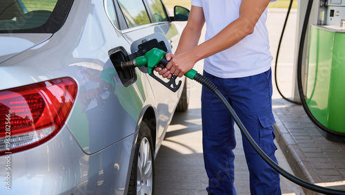 Quadro su tela man with gas pump, The vehicle is getting a full tank, The car is positioned nea