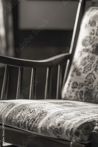 A classic wooden rocking chair sits in front of a window, perfect for relaxing and enjoying the view