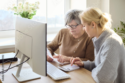 Photos Senior woman and daughter review bills online