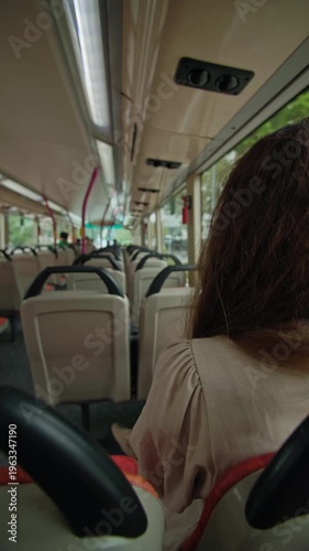 Female tourist riding city bus in Singapore looking through window, urban travel experience and public transport journey in Asia