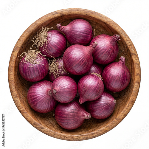 A wooden bowl filled with a large group of fresh whole red onions displaying their papery skin and wispy roots, isolated on white background