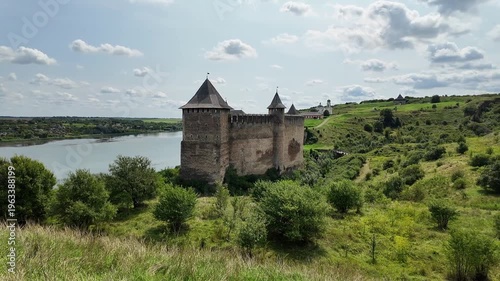 Wide panoramic view of Khotyn Fortress filmed from a distant hill, showing defensive slopes and the Dniester River below. Camera moves smoothly from left to right, emphasizing scale and landscape.