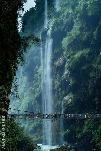 Zhangjiajie Canyon Waterfall with Suspended Bridge and Lush Vegetation