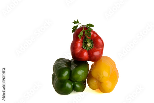 Three Color Bell Peppers Stacked On White Background With Parsley Garnish, Fresh Produce Close-Up