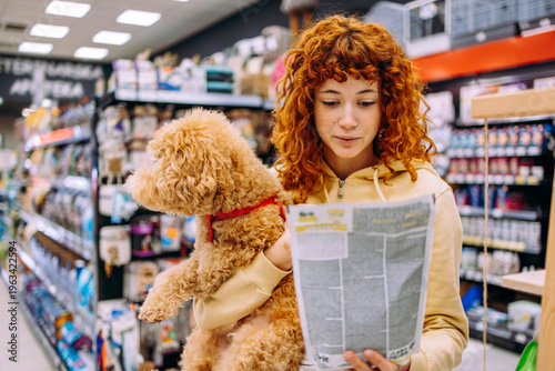 Women in a pet shop, having fun with her dog