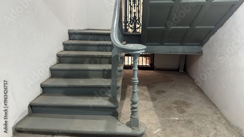 Vintage Grey Staircase with Ornate Cast Iron Railing