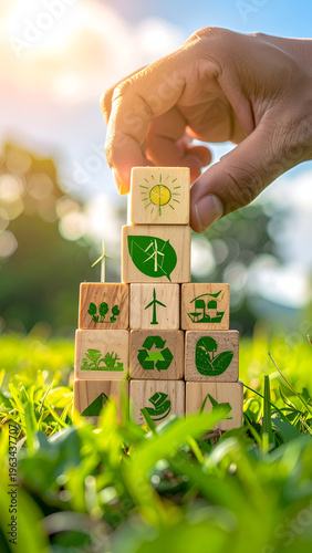 Eco building blocks pyramid on grass held by a hand