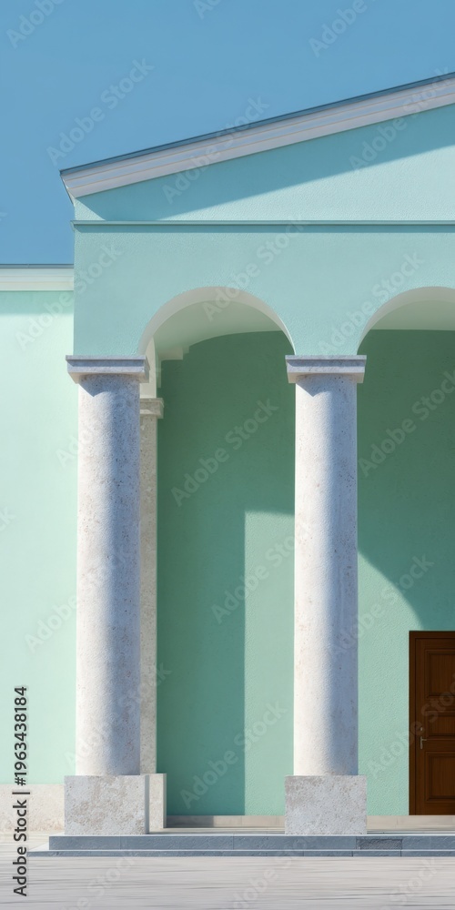 Fototapeta premium Pastel mint classical facade with three marble columns arched colonnade and wooden door under soft daylight showcasing mediterranean inspired architecture