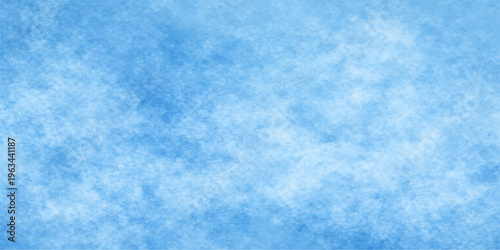 A soft abstract blue sky background features fluffy white clouds and a frozen winter texture of cold light snowflakes for a serene nature pattern