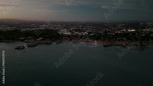 Aerial Orbit of Evaristo Coast and Town Lights at Dusk in Albufeira Algarve Portugal