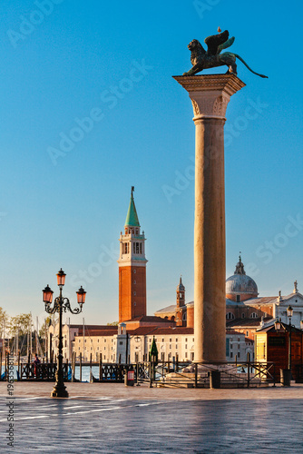 Piazza San Marco, Venice, Italy, and Basilica di Giorgio Maggiore. Piazza San Marco,  The lion of St Mark column. Romantic walk in Venice at sunrise with view of the basilica di Giorgio Maggiore.