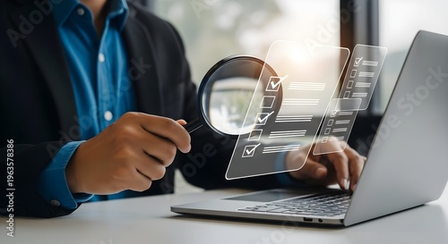 Businessman examining a laptop screen with a magnifying glass closely